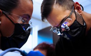 An oral surgeon and his assistant performing surgery