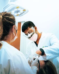 An oral surgeon and an assistant examining a patient