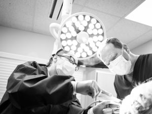 An oral surgeon and assistant performing a procedure